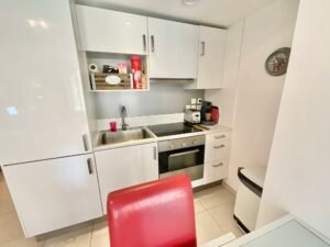 Cuisine moderne entièrement équipée avec plan de travail et électroménagers.