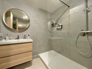 Salle de douches moderne dans un appartement à Sainte-Maxime, avec douche à l'italienne, carrelage élégant et éclairage soigné.