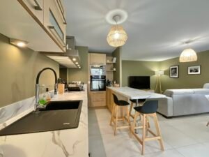 Cuisine moderne et équipée dans un appartement à Sainte-Maxime, avec mobilier élégant, plan de travail spacieux et électroménager intégré.
