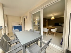 Terrasse spacieuse d’un appartement à Sainte-Maxime, équipée de six chaises, table à manger