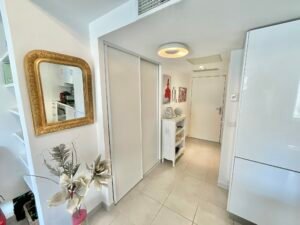 Entrée de l'appartement avec placard et accès à la salle de douche.