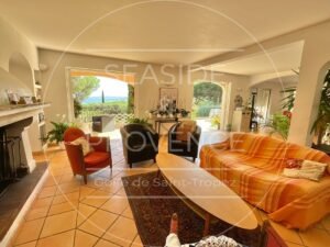 Vue sur la mer depuis un grand salon ouvert sur une terrasse, espace lumineux et élégant.