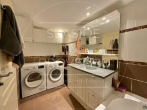 Grande salle de bains avec baignoire, lave-linge et sèche-linge dans un appartement à vendre à Sainte-Maxime, résidence Murano.