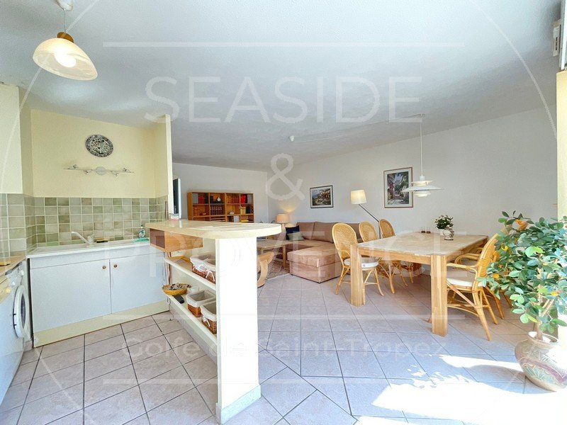 Séjour lumineux vu depuis la cuisine, espace ouvert et moderne dans appartement à Sainte-Maxime.