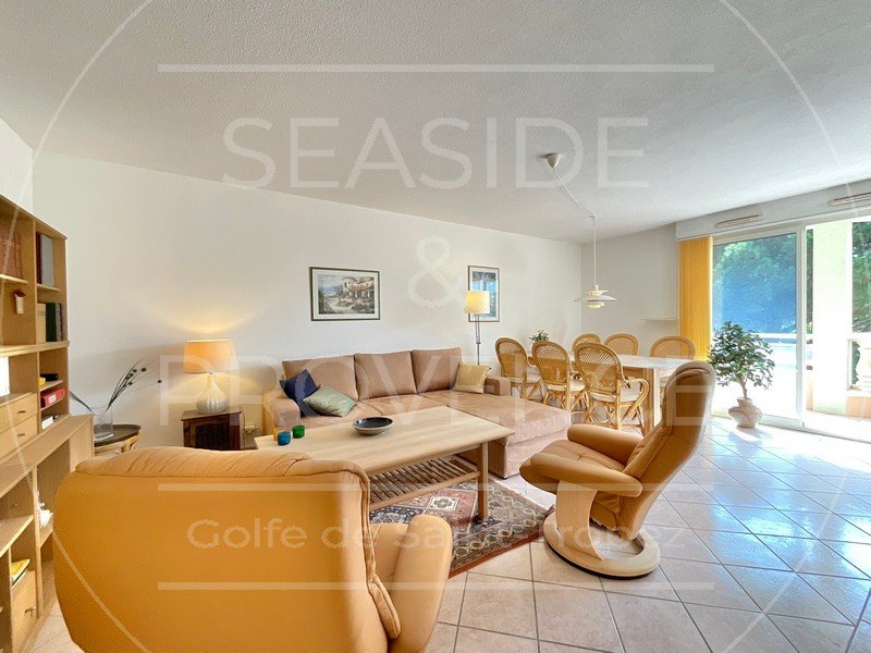 Salon lumineux avec cuisine ouverte et terrasse, vue depuis l’entrée de l’appartement à Sainte-Maxime.