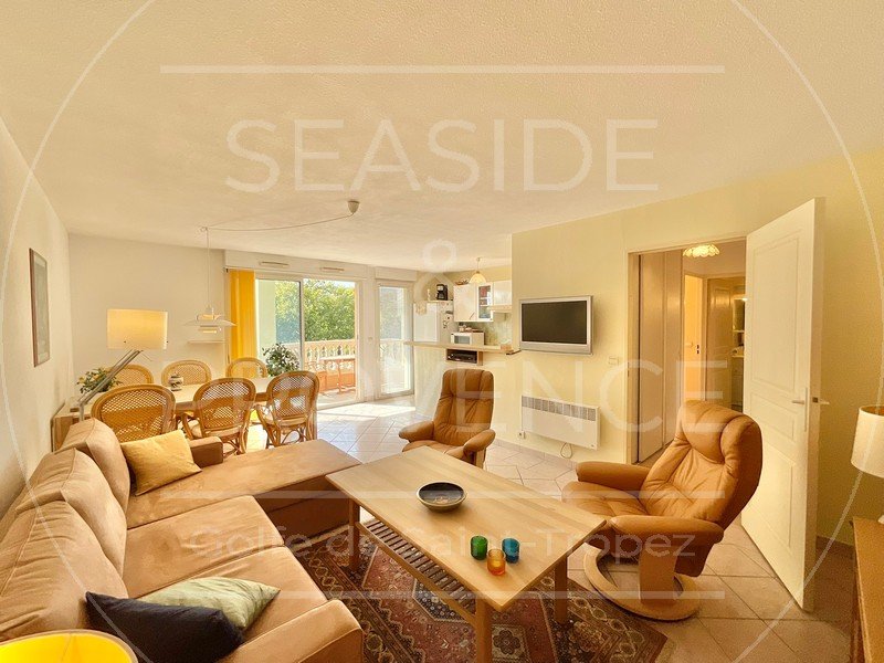Séjour lumineux avec cuisine ouverte et accès terrasse dans appartement 2 pièces à Sainte-Maxime.