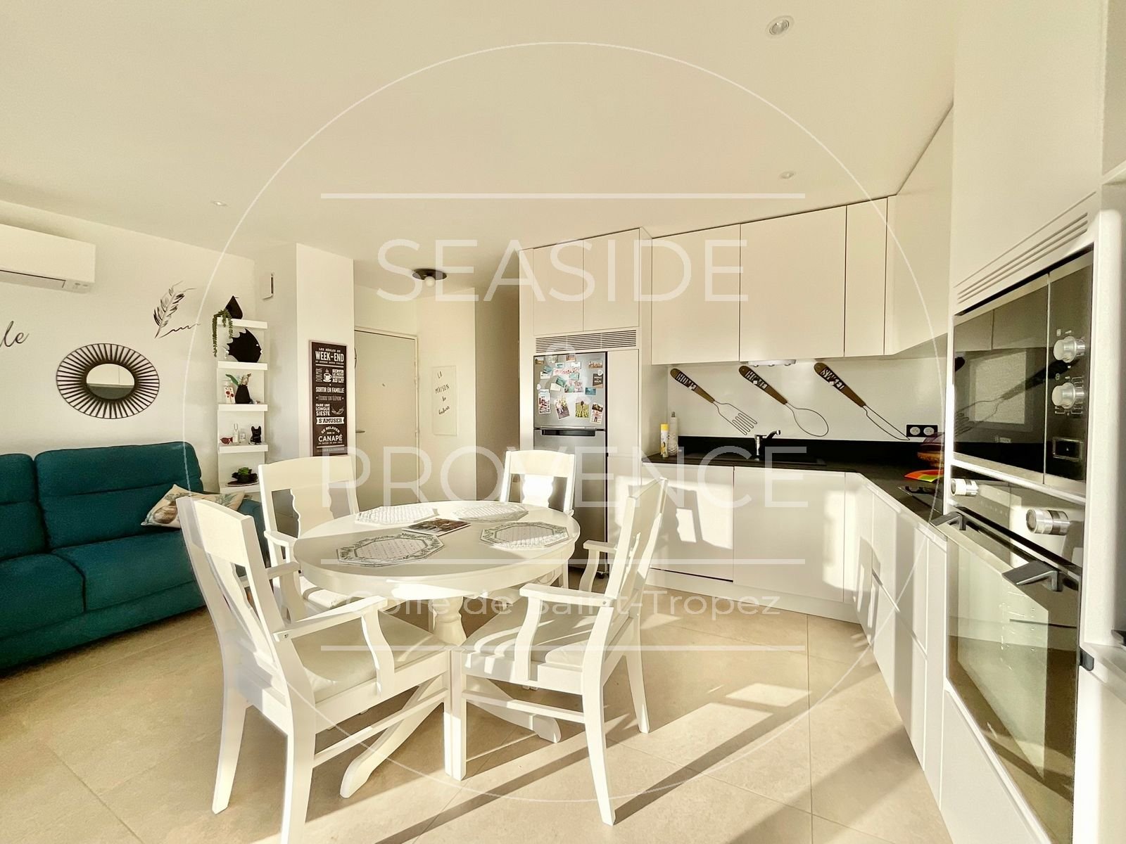 Salon lumineux avec cuisine ouverte et vue mer dans appartement rénové à Sainte-Maxime