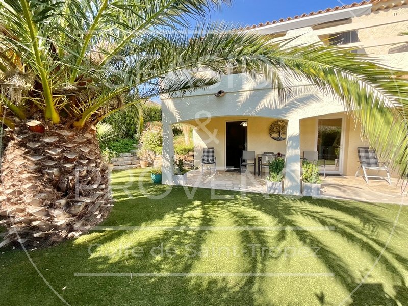 Terrasse couverte donnant sur un jardin méditerranéen avec palmier